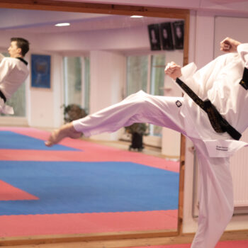 Mand udfører spark i taekwondo