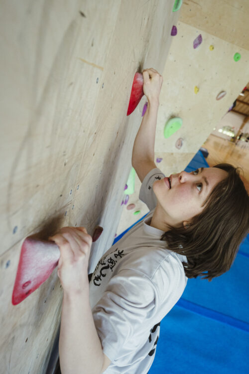 kvinde klatre på bouldering væggen på Bosei