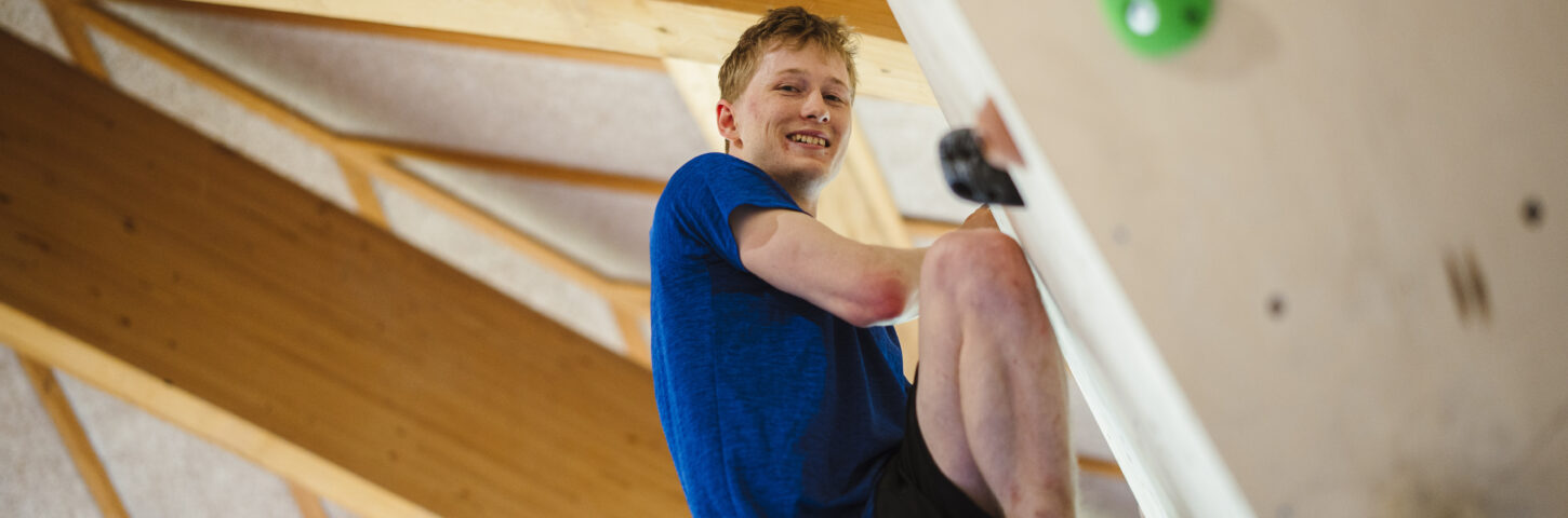 mandlig elev klatrer på bouldering væg