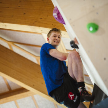 mandlig elev klatrer på bouldering væg