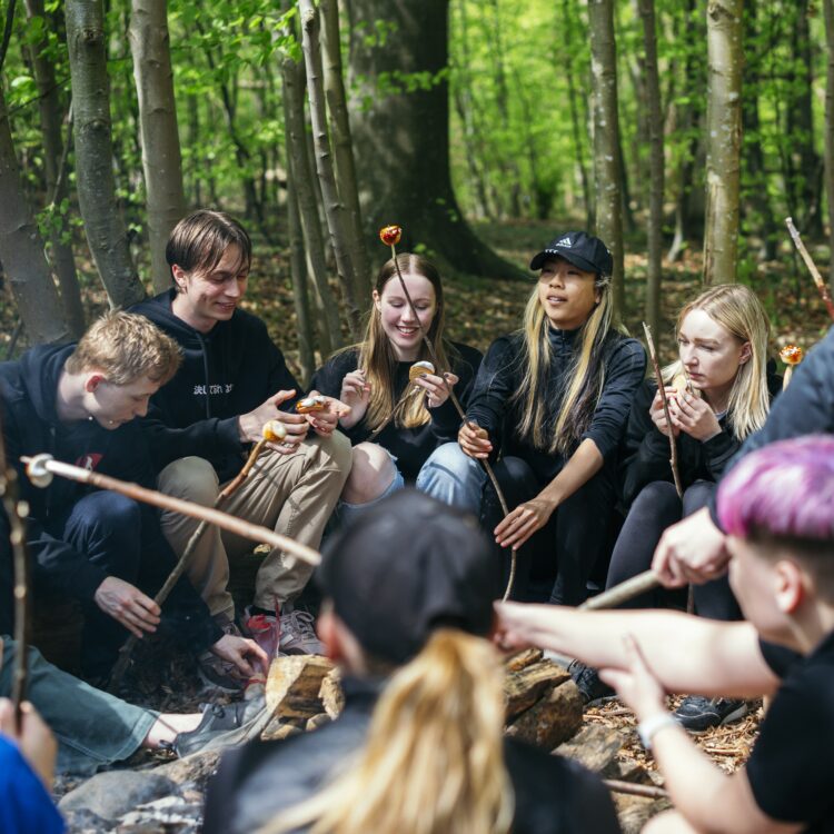 Elever griller skumfiduser over bål